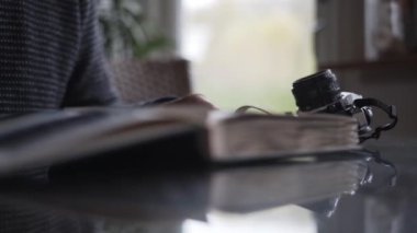 Adam Fotoğraf Albümünü Kapatıyor ve Kamerayı Tutuyor
