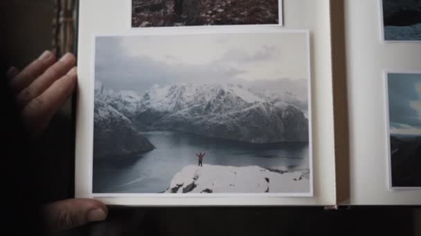 Man kijkt naar foto 's van zichzelf op een berg — Stockvideo