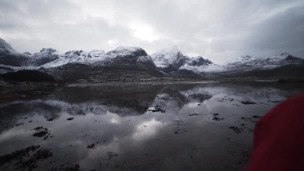 Escursionista guardando le montagne riflesse nel fiordo — Video Stock