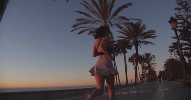 Junge Frau läuft Strandpromenade entlang — Stockvideo