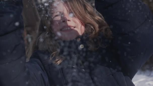 Menina desfrutando do clima de inverno jogando neve no ar em Slowmo — Vídeo de Stock