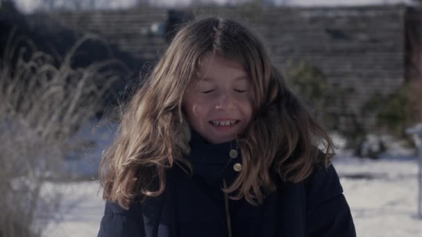 Όμορφο μικρό παιδί χαμογελώντας με χιονόμπαλα ρίχνονται στο πρόσωπό της σε αργή κίνηση — Αρχείο Βίντεο