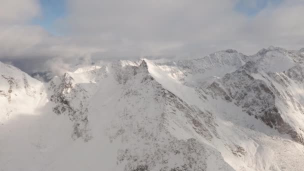 Colpo aereo panoramico delle montagne coperto di neve spessa bianca durante il giorno — Video Stock