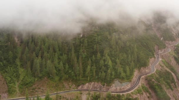 Воздушный пейзаж дороги у гор и туман, покрывающий пик — стоковое видео