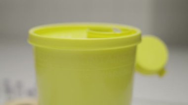 Doktor kullanılmış şırıngayı çöp konteynırına koydu.