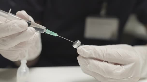 Доктор вводит жидкость в ковидную вакцину — стоковое видео