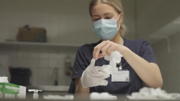 Доктор в маске надевает хирургические перчатки — стоковое видео