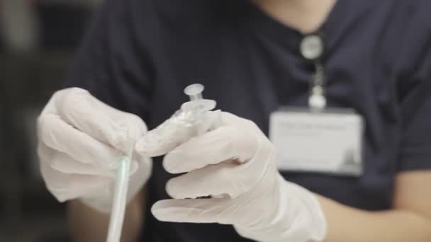 Доктор в хирургических перчатках, готовит шприц — стоковое видео