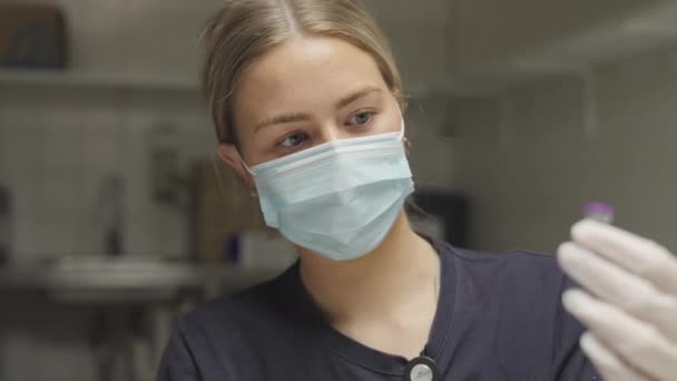 Доктор в перчатках задерживает вакцину против ковида — стоковое видео