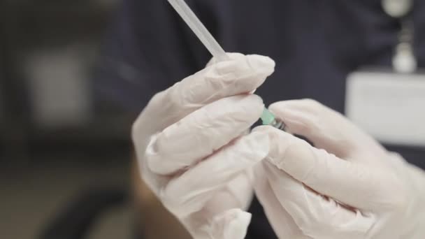 Arzt in OP-Handschuhen bereitet Spritze vor — Stockvideo