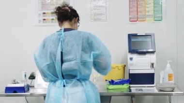 Doktor Önlüklü ve Yüz maskeli Örnek Hazırlıyor