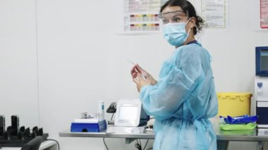 Doktor Önlüklü ve Yüz maskeli Örnek Hazırlıyor