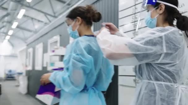 Krankenschwester im gesicht schild binden peelings von doktor — Stockvideo