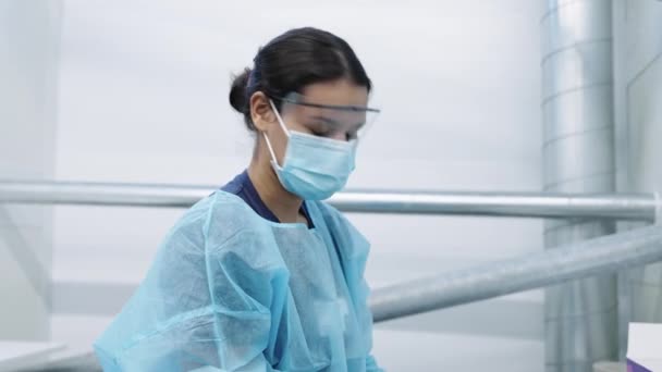 Доктор в маске надевает перчатки — стоковое видео