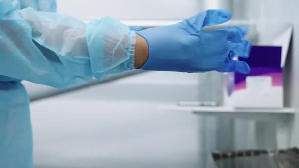 Доктор в скрабах надевает хирургические перчатки — стоковое видео