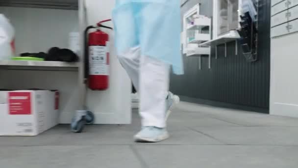 Врач в кроссовках и скрабах, идущий в больницу — стоковое видео