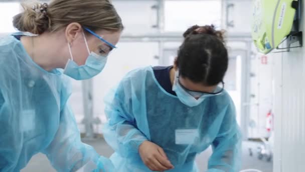 Молодые женщины-врачи в скрабах и масках — стоковое видео