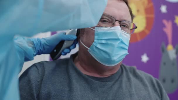 Доктор в голубой форме с помощью отоскопа — стоковое видео