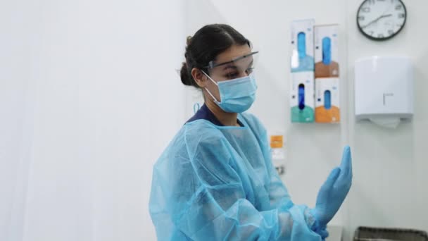 Врач в синих скрабах и маске для лица консультирует пациента — стоковое видео