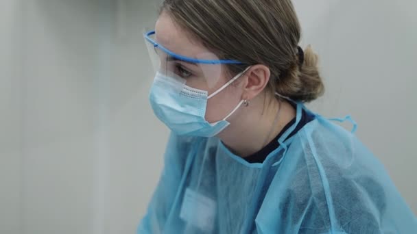 Доктор в маске делает заметки — стоковое видео