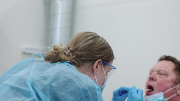 Доктор проверяет мужскую глотку у пациентов — стоковое видео