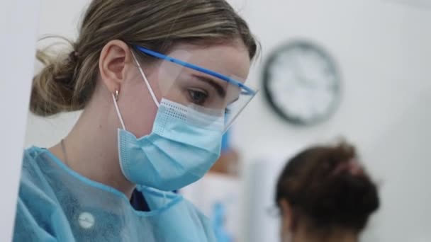 Vrouwelijke artsen in blauwe scrubs en maskers — Stockvideo