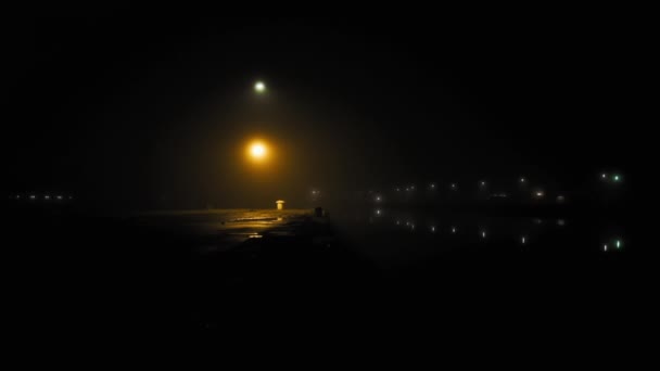 Lámpaoszlop fény a városi kikötőben a ködös éjszakán — Stock videók