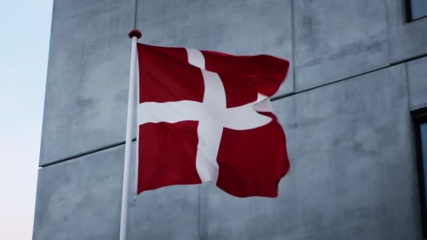 丹麦国旗在灰屋外迎风飘扬 — 图库视频影像