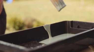 Boya fırçasını tepsiye daldıran adam