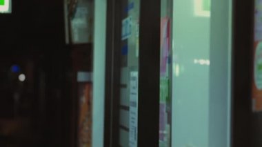 Dükkandan elinde bir şişe hapla gelen adam.