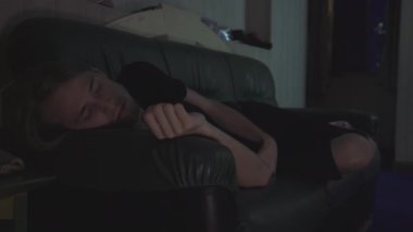 Depresyondaki adam kanepede uyuyor sonra uyanıyor ve tekrar ayağa kalkıyor.