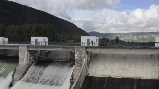 Homem observando o fluxo de água através da barragem hidroelétrica — Vídeo de Stock