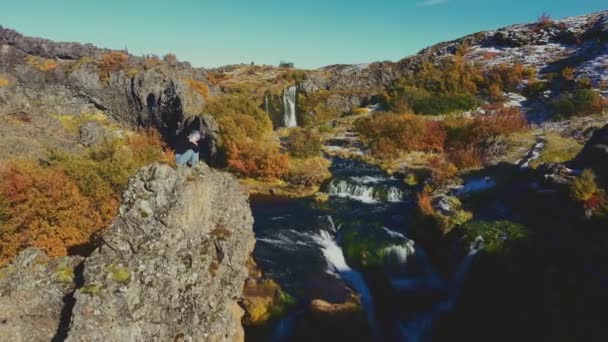 Drone of Rock Climber siedzi na szczycie skał nad rzeką — Wideo stockowe