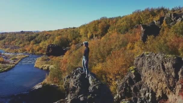 Drone of Female Boulderer en la parte superior de rocas sobre el río — Vídeo de stock