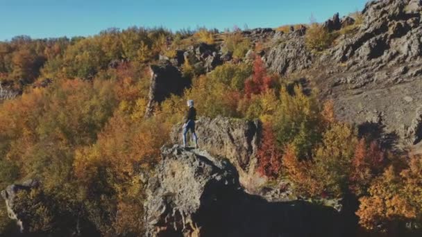Dron żeńskiego głazu na szczycie skał w dramatycznym krajobrazie — Wideo stockowe