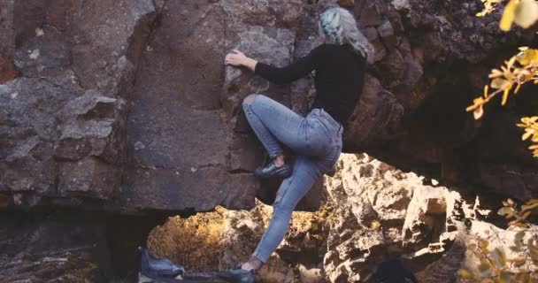 Mulher com cabelo azul escalada rochas íngremes — Vídeo de Stock