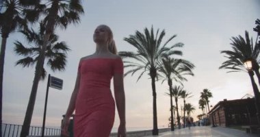 Pembe Elbiseli Güzel Kadın Düz ve Sahilde Yürüyor