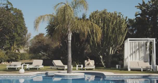 Rangée de chaises longues du jardin de la cour arrière et une femme allongée — Video