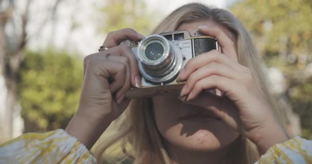 Kopfschuss einer aufblickenden Frau, die ein Foto mit ihrer Vintage-Kamera macht — Stockvideo