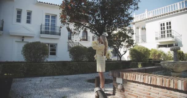 Kobieta stojąca na podwórku Ogród z zabytkową kamerą próbuje zrobić zdjęcia — Wideo stockowe