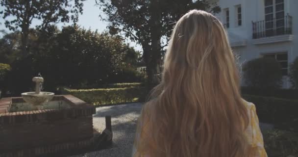 Tânăra femeie care merge în grădină plină de design peisagistic frumos — Videoclip de stoc