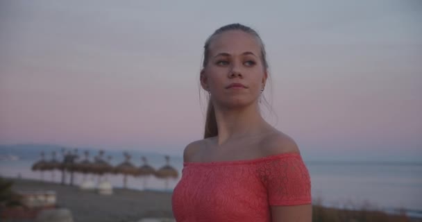 Jonge vrouw aan het strand op zoek zijwegen en eindeloze zeegezicht — Stockvideo