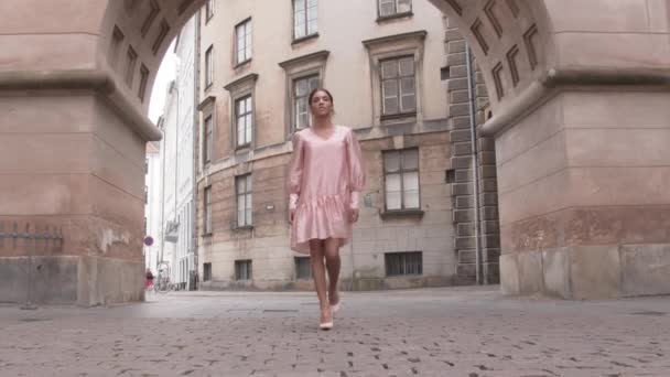 Mujer en rosa caminando por el casco antiguo — Vídeo de stock