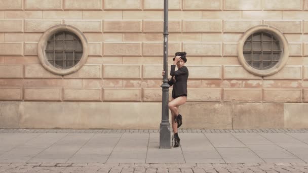 Danser bewegend en poseren in top hoed rond straatlantaarn — Stockvideo