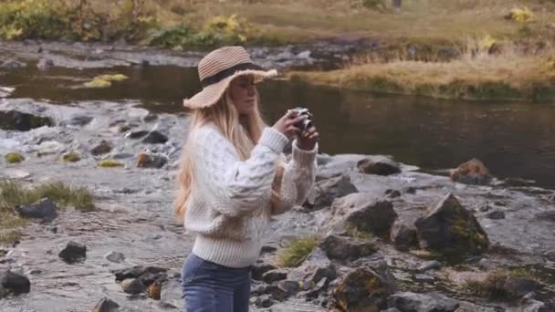 Kobieta fotografowania w rzece ze starym aparatem — Wideo stockowe