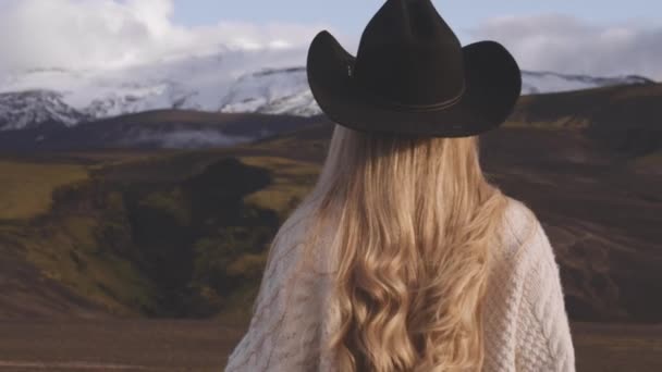 Blond vrouw in cowboy hoed kijken naar bergen — Stockvideo