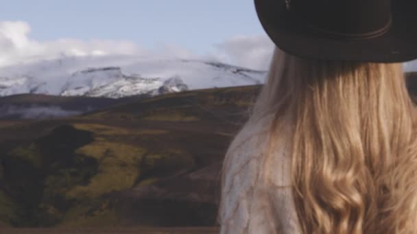 Meisje in cowboy hoedje op zoek naar bergen in IJsland — Stockvideo