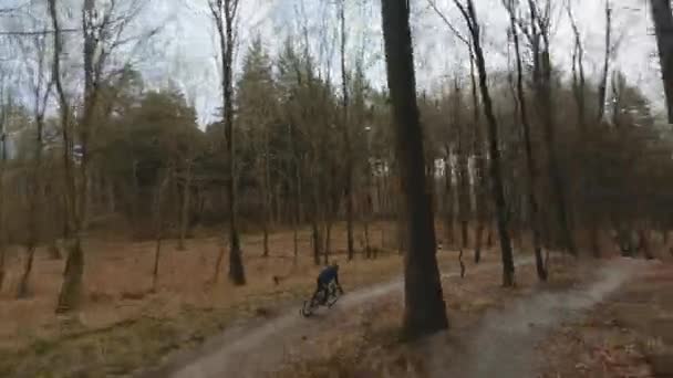 Drone Flight efter cyklist racing genom skogen — Stockvideo