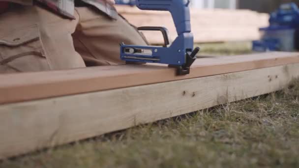 Carpintero poniendo tornillos en la cubierta de madera — Vídeo de stock