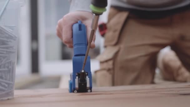 Плотник помещает винты в деревянную рамку — стоковое видео
